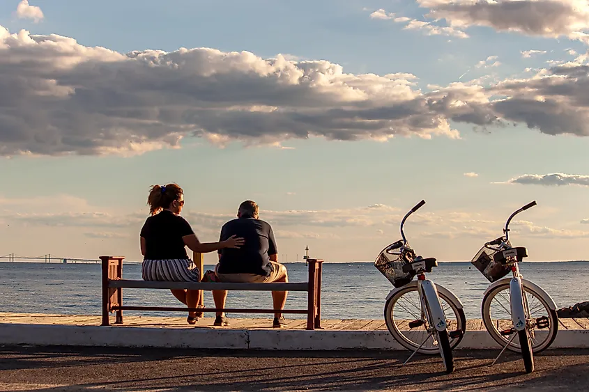 A couple sitting on a bench by the beach in Rock Hall, Maryland.