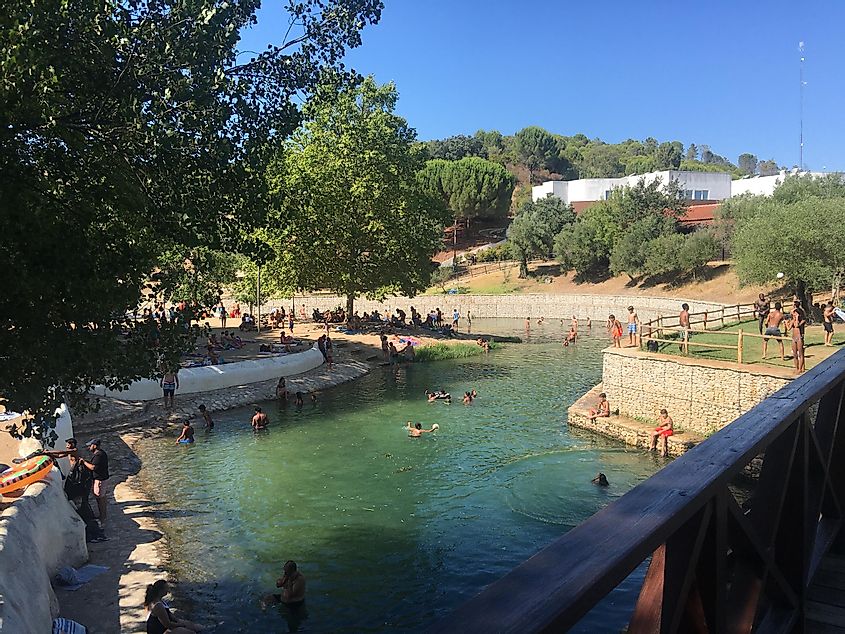 Lots of people splashing around in a river in Portugal. 