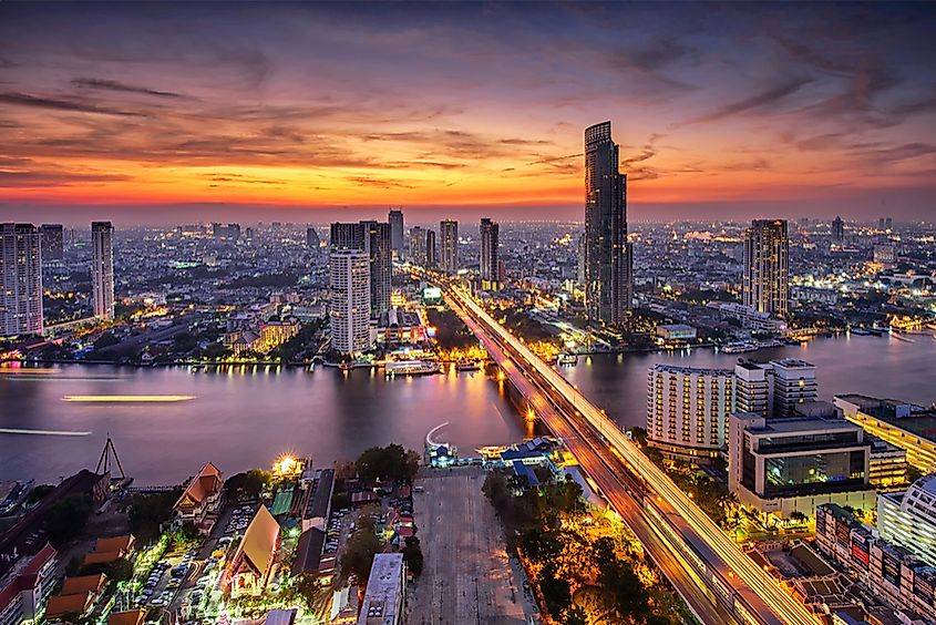 The Bangkok skyline at sunset along the Chao Phraya River, Thailand.