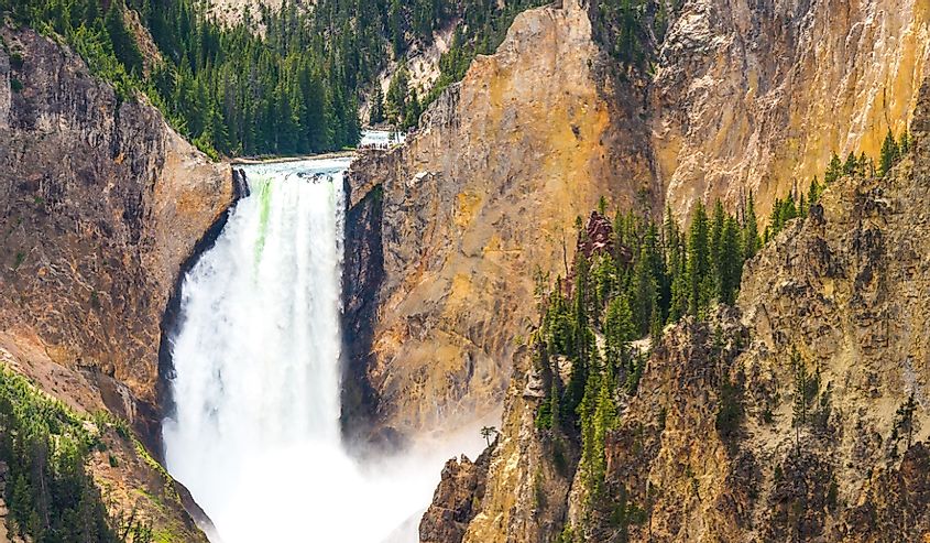 The Upper Falls of the Yellowstone River with mountains and evergreens