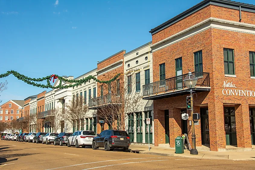 Natchez, USA – December 2, 2022 - View of the historic Natchez Main Street with Convention Center, 19th century buildings, parked cars and Christmas decorations, Adams County, Mississippi