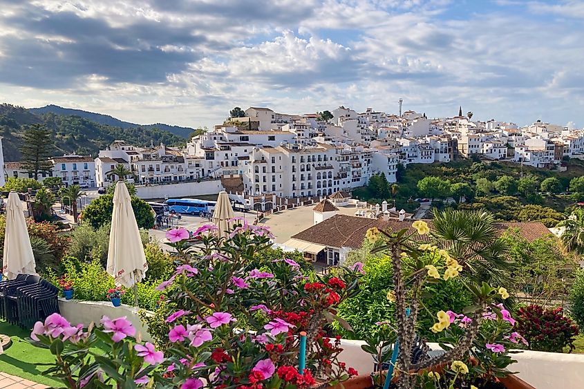 peaceful walk through the charming narrow streets, surrounded by whitewashed houses and colorful flowers in Frigiliana, Spain.