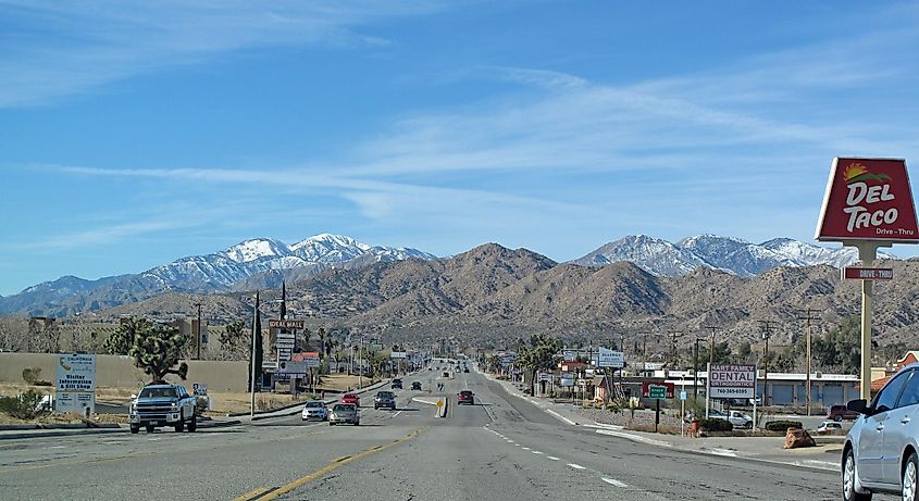 View west in Yucca Valley, CA along CA State Route 62 (Twentynine Palms Highway). The San Bernardino Mountains are in the distance
