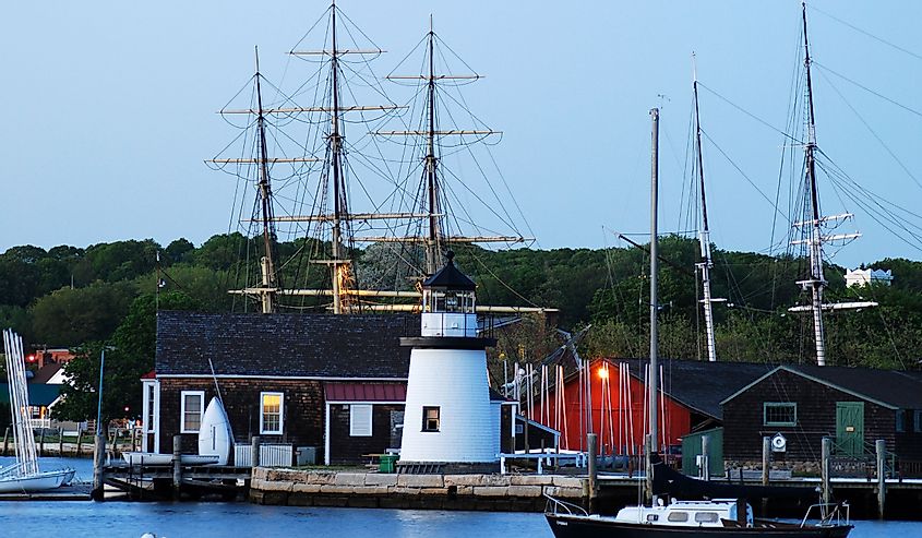 A quiet calm falls upon the Mystic Seaport in Connecticut, where tall masts of an historic wooden whaling ship towers over a small lighthouse