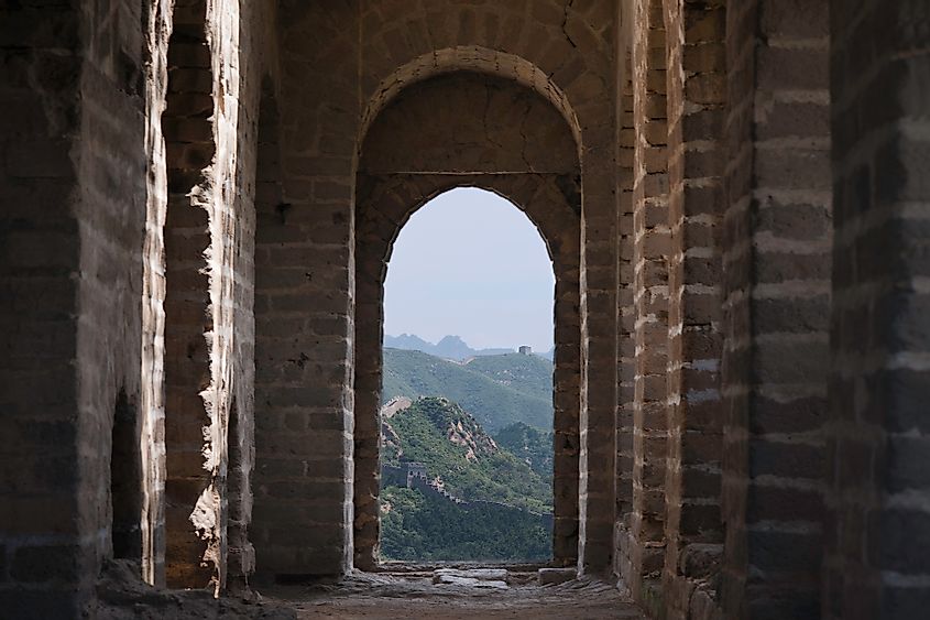 View through a brick window of a Fortress Guard Tower of Mutianyu, a section of the Great Wall of China during summer.