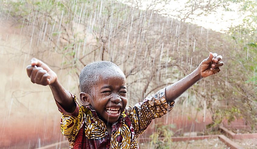 Young boy in African rain. 