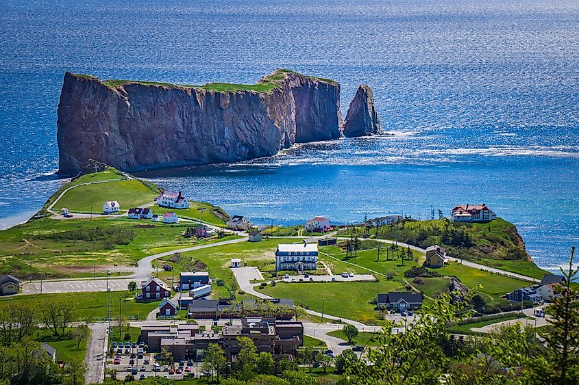 Editorial Photo Credit: Pernelle Voyage. View on the Percé rock, the ocean, the cape Mont Joli, and the Percé Village from the Unesco Geopark and their Belvedere hiking trail