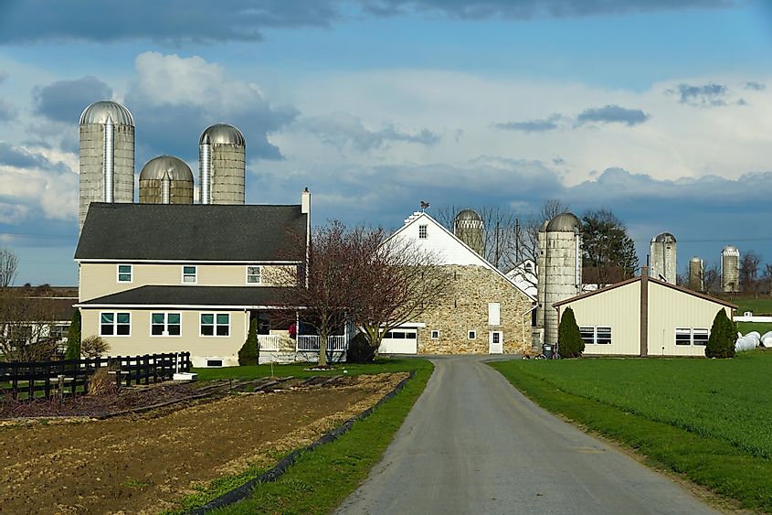 A large Amish farm with corn silos, via Khairil Azhar Junos / Shutterstock.com