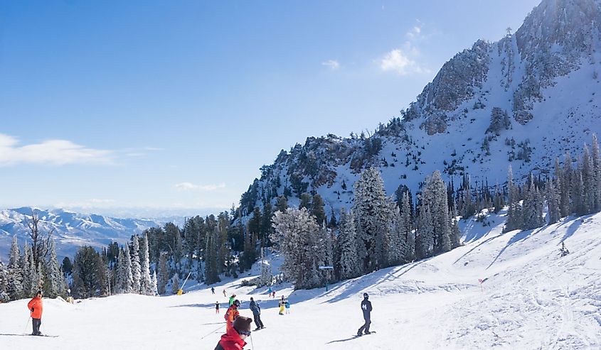 Лыжники и сноубордисты наслаждаются солнцем в день открытия горнолыжного курорта Сноубасин.