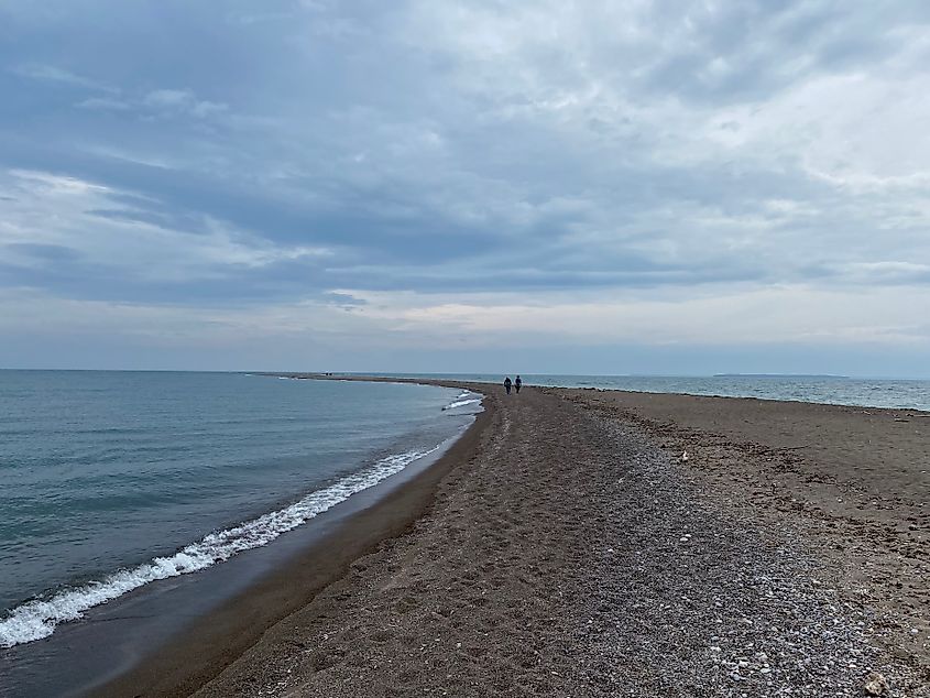 A long sand spit leads out into Lake Erie on an overcast day.