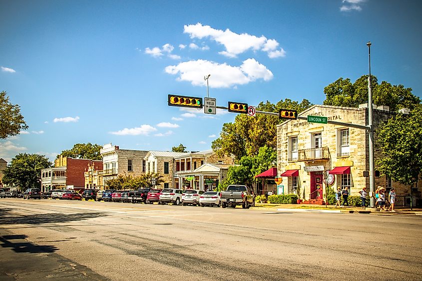 Main Street in Fredericksburg, Texas, USA, known as "The Magic Mile," featuring retail stores and people walking