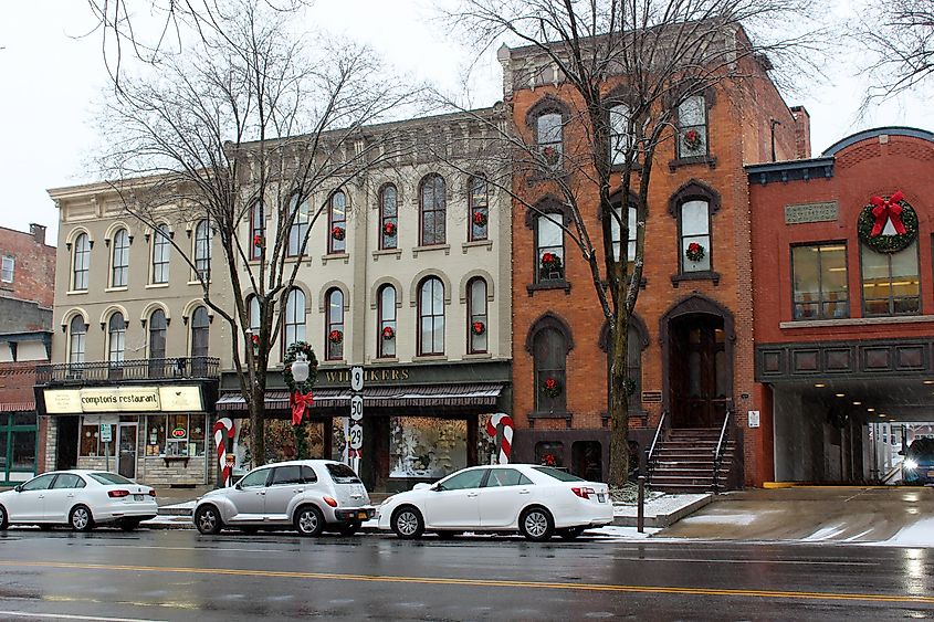 Downtown Broadway in Saratoga Springs, where shops are decorated for the holidays and cars are parked along the busy street for shoppers to finish their holiday purchases