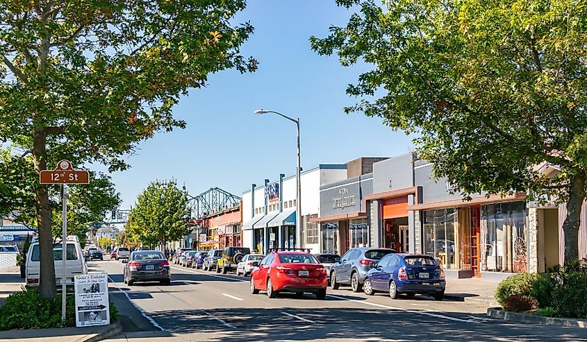 Cars on the street in downtown Astoria with Astoria-Megler Bridge in the background