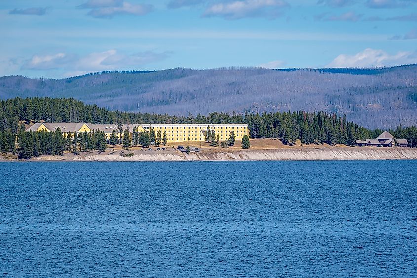 The National Historic Landmark - Lake Yellowstone Hotel, with the Yellowstone lake in the foreground and mountains in the background.