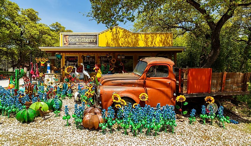 Colorful shop with artwork on display of truck and flowers in the small Texas Hill Country town of Wimberley, Wimberley, Texas