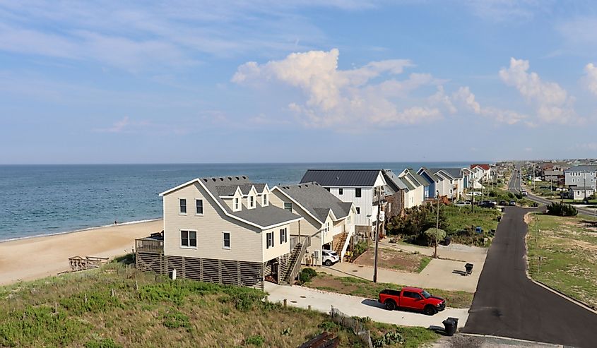 A wide aerial view of homes that stand along the Atlantic Ocean sand dunes and Highway 12 in the Outer Banks