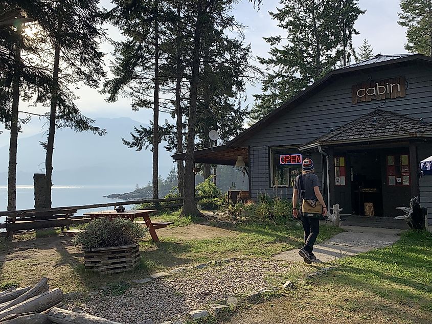 A man walks into a cozy, lakeside restaurant bar