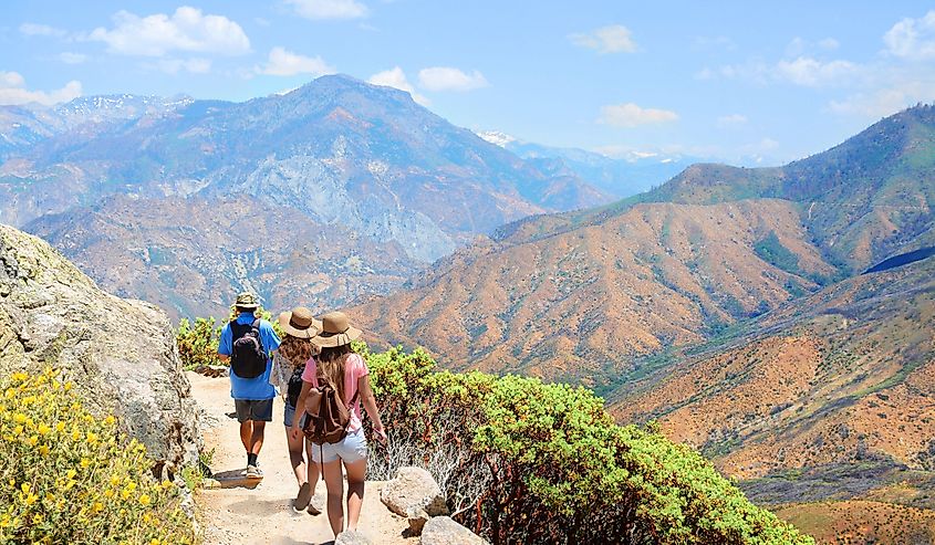 Family with backpacks on hiking trip , High mountains landscape with cloudy sky. Kings Canyon National Park, Fresno, California