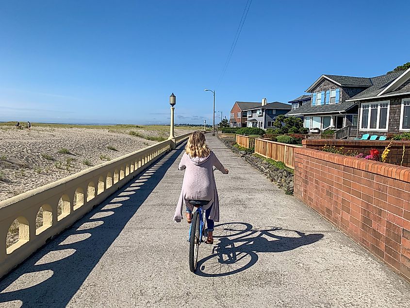 Seaside, Oregon: Woman biking on the Promenade.