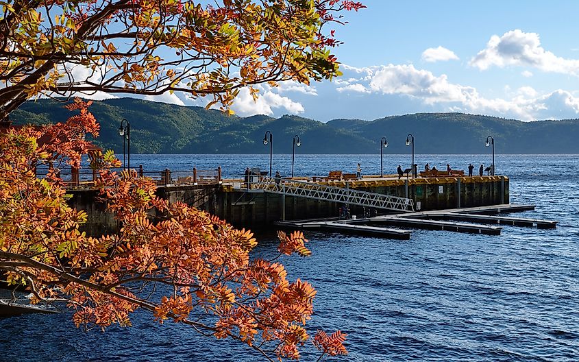 Tourists walking along a pier at sunset in Sainte-Rose-du-Nord, Province of Quebec.