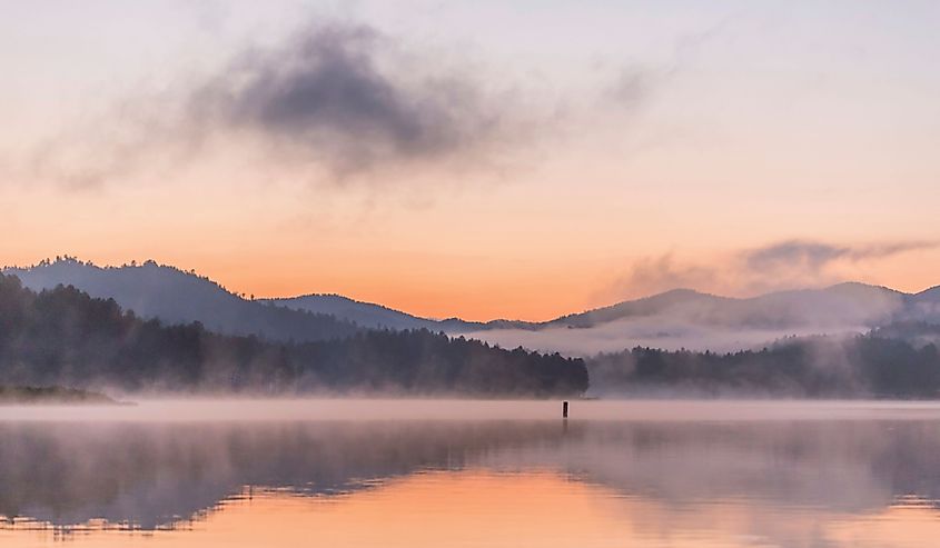 A Telephoto Shot of the Black Hills Reflecting in a Foggy Lake Sheridan after Sunset