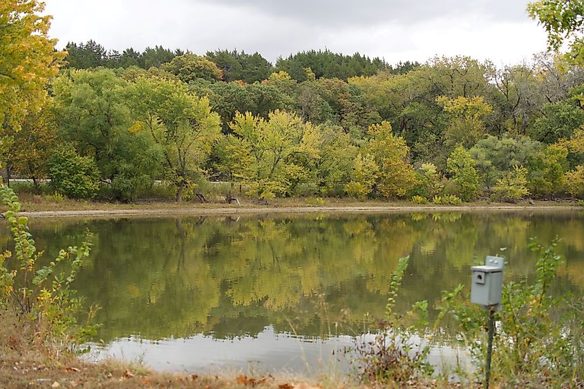 A landscape of Tuttle Creek Lake surrounded by greenery under a cloudy sky in Kansas.