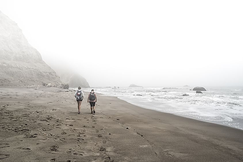 Two women walking down foggy beach - Point Reyes National Seashore