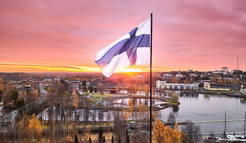 Aerial view of Finnish flag on the tower of Town Hall against the red sunrise sky in Joensuu, Finland.