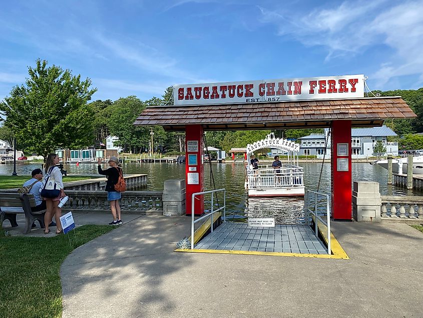A small crowd waits as Saugatuck's historic chain ferry cranks its way across the river.