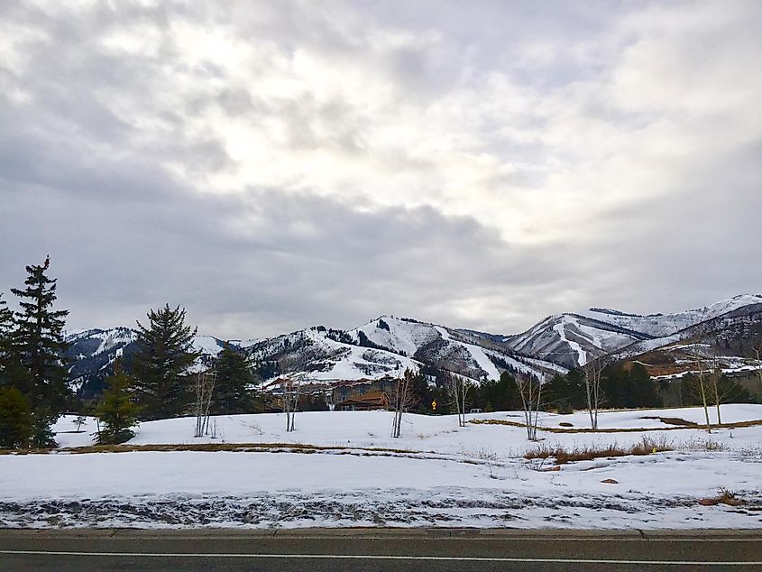 Mountains, snow and road with cloudy sky, Snyderville, Utah.