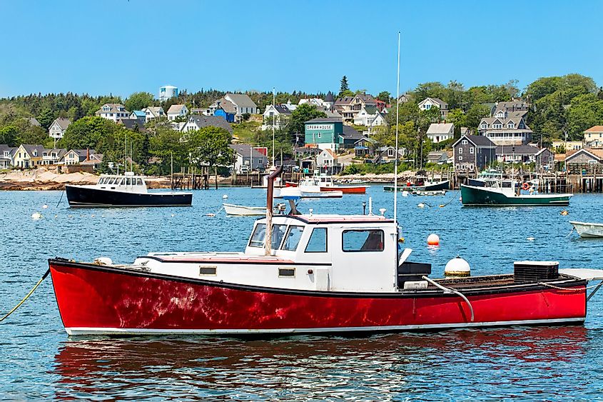 Harbor at Stonington, Maine, with a red lobster boat in the foreground.