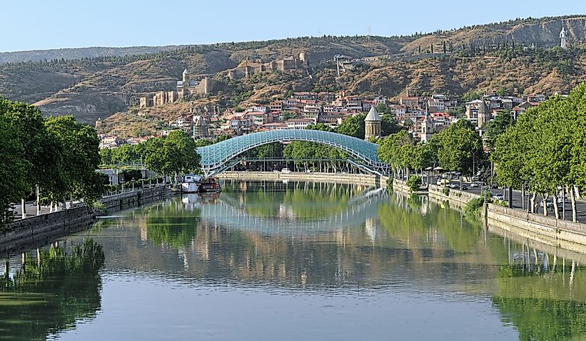 Pedestrian Bridge of Peace over the Kura River, Narikala Fortress and Kartlis Deda Monument in Tbilisi, Georgia
