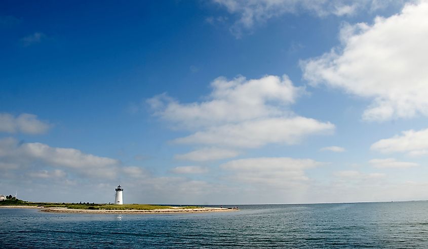 Lighthouse on island, Cuttyhunk, Massachusetts surrounded by the ocean and clouds in the sky