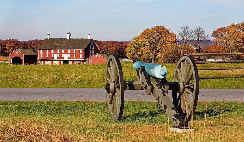 A cannon and a barn on the battlefield at Gettysburg National Military Park, Adams County, Pennsylvania, USA.