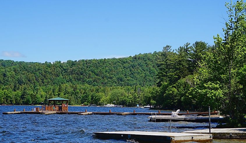 Wooden boat docks floating on the choppy water of Fourth Lake, located near the town of Inlet, New York.