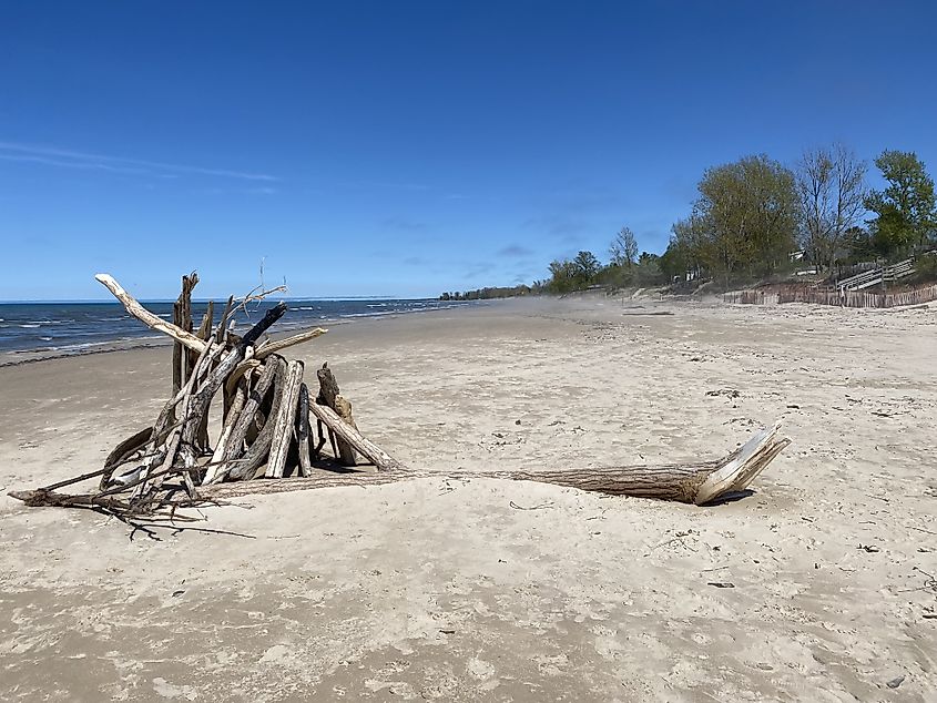 A beautiful and slightly misty day at a wild Lake Huron beach. A makeshift wood structure marks the foreground 