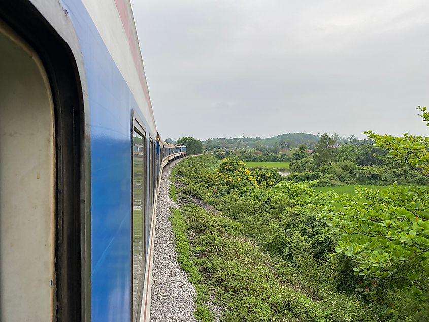 POV out the window of a train moving through a lush countryside.