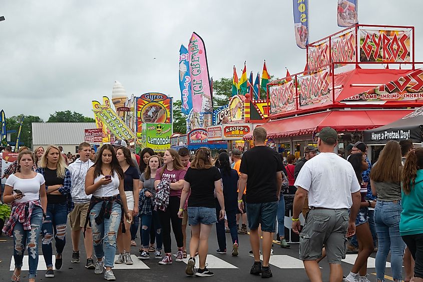 People walking the midway near concession stands and amusement rides in Fond du Lac, Wisconsin.