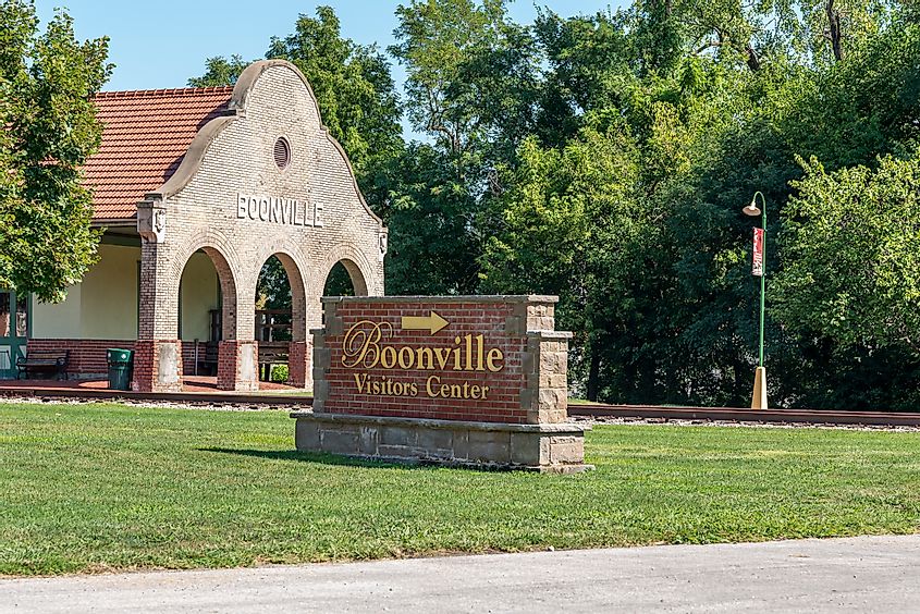City of Boonville Visitor Center sign, with historic train depot in background.