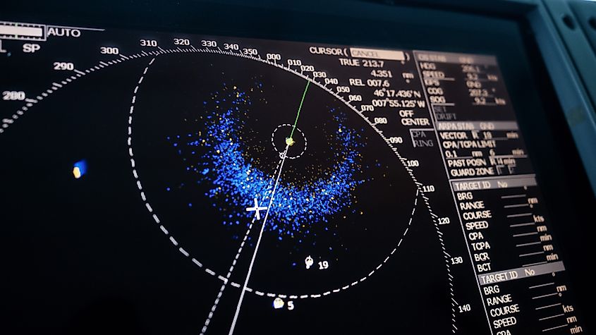 Close-up photo of a ship radar screen displaying nearby vessels, radar interface, and light signal interference
