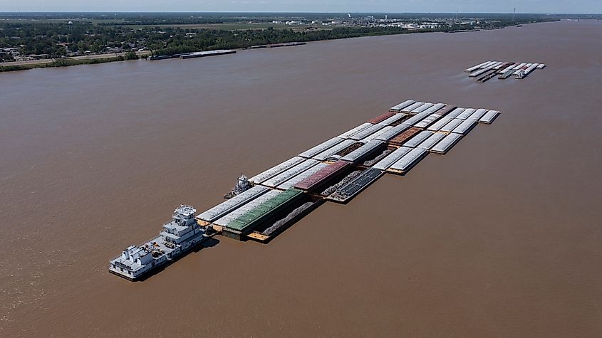 A towboat, known as a pusher, pushes barges full of cargo up the Mississippi River near downtown Baton Rouge, Louisiana, USA.