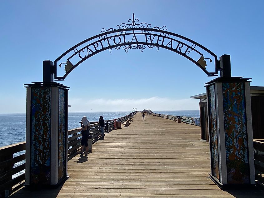 Blue skies over the branded arch entrance for Capitola's wooden wharf.
