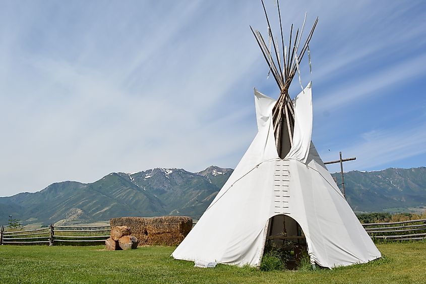 American West Heritage Center Teepee with barrels of hay, a wooden fence and Utah Mountains in the background.