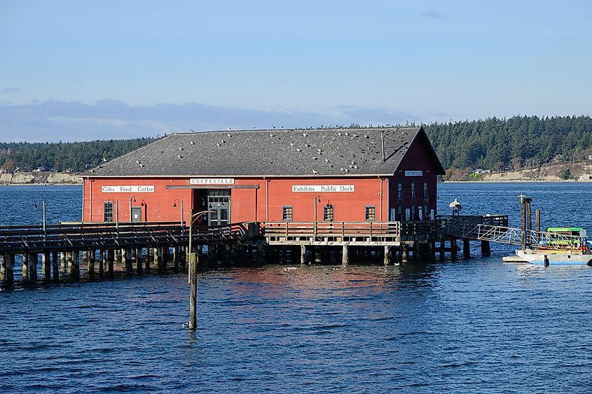 Red building on Coupeville Wharf at high tide in Penn Cove. Editorial credit: Ian Dewar Photography / Shutterstock.com