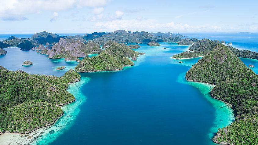 A remote lagoon, surrounded by limestone islands, protects a vibrant and diverse coral reef in Wayaq Island, Raja Ampat, Indonesia.