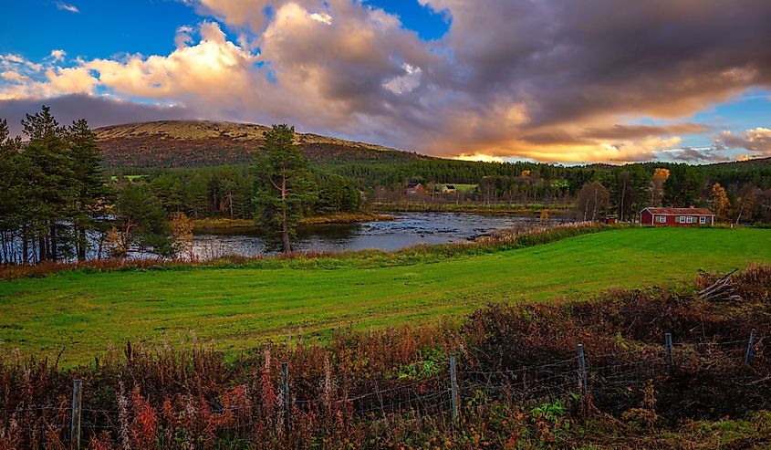 Sunset over a wooden cabin and Glomma River in Innlandet county, Norway.