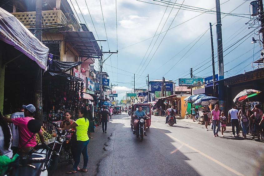 A busy road in small town Guatemala - motorcycles, tuk tuks and pedestrians all share the way