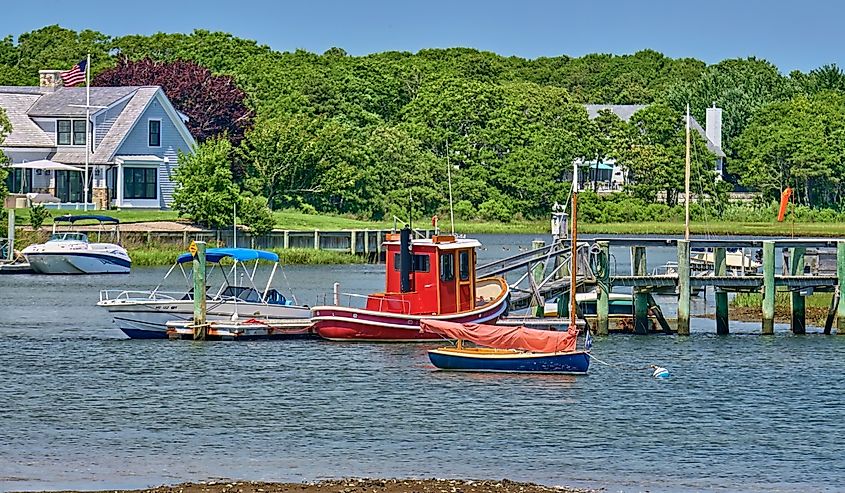 A cute little Red Tug boat, The Daisy Mae, at a dock or pier on Lewis Bay inlet in Cape Cod, Massachusetts, Near Hyannis Harbor.
