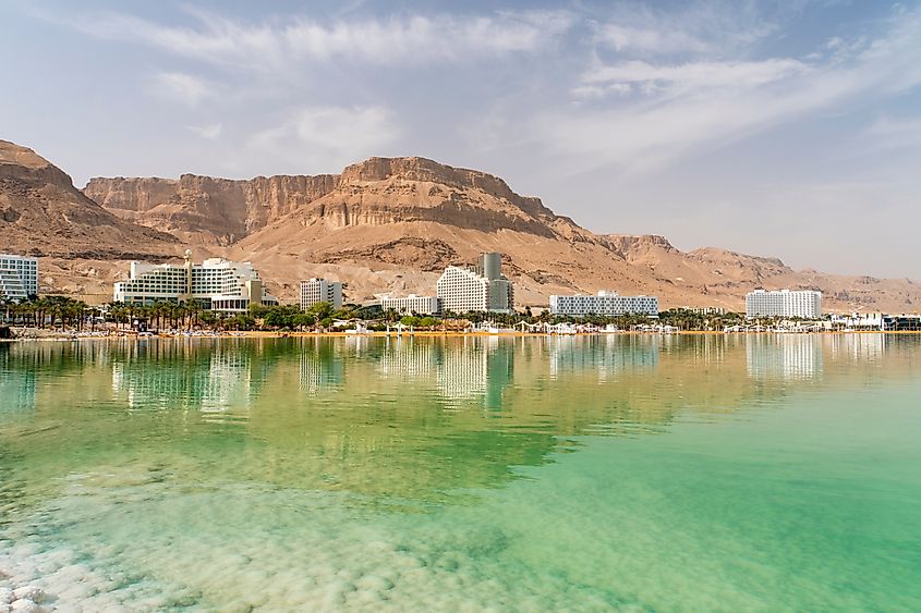 Dead sea salt shore. Salt on the background of the sea and the coastal resort town Ein Bokek, Israel