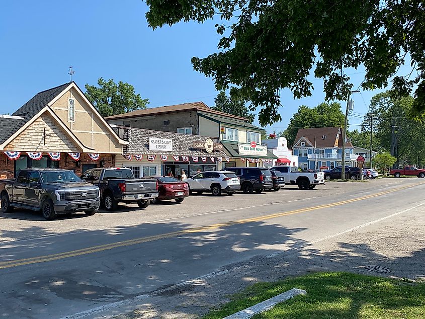 Cars line the stalls of indie businesses in a small town.